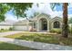 Charming single-story home featuring an arched entryway, well-manicured lawn, and a two-car garage at 16224 Magnolia Hill St, Clermont, FL 34714