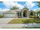 Charming single-story home featuring an arched entryway, well-manicured lawn, and a two-car garage at 16224 Magnolia Hill St, Clermont, FL 34714