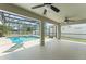 A spacious lanai features two ceiling fans, and a view of the sparking screened in pool and back yard at 16224 Magnolia Hill St, Clermont, FL 34714