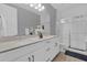 Bathroom featuring dual sinks, quartz countertops, modern cabinetry, and a glass enclosed shower at 16828 Sanctuary Dr, Winter Garden, FL 34787