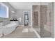 Bright bathroom featuring a soaking tub, shower with glass door, and view to an open doorway at 16828 Sanctuary Dr, Winter Garden, FL 34787