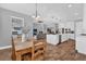 Open-concept dining area flowing into a modern kitchen and living space with hardwood floors at 16828 Sanctuary Dr, Winter Garden, FL 34787