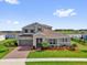 Charming two-story home showcasing a well-manicured front lawn and a brick driveway leading to a two-car garage at 16828 Sanctuary Dr, Winter Garden, FL 34787