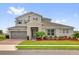 Charming two-story home featuring a stone accent entry, gray trim and siding, manicured lawn and well-kept landscaping at 16828 Sanctuary Dr, Winter Garden, FL 34787