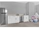 Bright and modern entertainment area with white cabinets, stainless steel appliances, and cozy playroom at 16828 Sanctuary Dr, Winter Garden, FL 34787