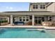 Covered patio with outdoor seating, kitchen, and a pool, perfect for outdoor entertainment and relaxation by the pool at 16828 Sanctuary Dr, Winter Garden, FL 34787