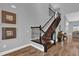 Staircase boasts hardwood steps, decorative black iron railings, and hardwood floors throughout the foyer at 16828 Sanctuary Dr, Winter Garden, FL 34787