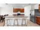 Modern kitchen features a large island with seating, stainless steel refrigerator, and brown cabinets at 2024 Griffin Oaks Way, Tavares, FL 32778