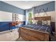 Comfortable bedroom with blue and white walls, decorated with lacrosse sticks and a wooden bed frame at 2219 Lake Preserve Cir, New Smyrna Beach, FL 32168