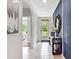 Bright foyer with a modern console table, elegant mirror, and beautiful artwork, creating an inviting entrance at 2219 Lake Preserve Cir, New Smyrna Beach, FL 32168