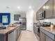 Modern kitchen featuring gray cabinetry, stainless steel appliances, and granite countertops at 2219 Lake Preserve Cir, New Smyrna Beach, FL 32168