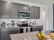 Modern kitchen with gray cabinets, stainless steel appliances, and granite countertops at 2219 Lake Preserve Cir, New Smyrna Beach, FL 32168