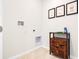 Bright laundry room with tile flooring and a modern cabinet, equipped with washer and dryer hookups at 2219 Lake Preserve Cir, New Smyrna Beach, FL 32168