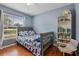 Comfortable bedroom with blue accent wall, hardwood floors, and a bookcase filled with books at 239 Bronze Leaf Ct, Apopka, FL 32703