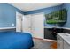 This bedroom offers blue walls, hardwood floors, and a mounted television at 239 Bronze Leaf Ct, Apopka, FL 32703