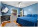 Stylish bedroom features blue walls, hardwood floors, a ceiling fan, and modern furnishings at 239 Bronze Leaf Ct, Apopka, FL 32703