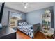 Cozy bedroom with blue accent wall, hardwood floors, and a charming bookcase for books and toys at 239 Bronze Leaf Ct, Apopka, FL 32703