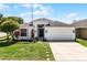 Charming single Gathering home featuring a landscaped yard, a two car garage, and a covered entryway at 239 Bronze Leaf Ct, Apopka, FL 32703