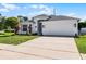 Well-maintained home with a two-car garage, manicured lawn, and minimalist landscaping that enhances curb appeal at 239 Bronze Leaf Ct, Apopka, FL 32703