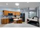 Well-lit kitchen featuring warm wood cabinets, stainless appliances, tile flooring, and an island at 239 Bronze Leaf Ct, Apopka, FL 32703