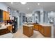 Spacious kitchen with stainless steel appliances, a center island, and a seamless flow into adjacent living spaces at 239 Bronze Leaf Ct, Apopka, FL 32703