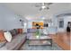 Open concept living room with view into the kitchen, fan and wood floors at 239 Bronze Leaf Ct, Apopka, FL 32703