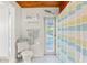 Cozy white tiled bathroom featuring a decorative lizard, striped shower curtain, and natural light at 2413 Weber St, Orlando, FL 32803