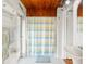 White bathroom with shower curtain and wood paneling at 2413 Weber St, Orlando, FL 32803