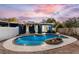 A kidney-shaped pool with integrated water feature creates a refreshing backyard oasis under a beautiful evening sky at 2413 Weber St, Orlando, FL 32803