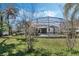 Wide backyard view featuring a screened-in pool with trees and green grass at 243 Shady Oaks Cir, Lake Mary, FL 32746