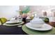 Close-up of dining table setting with green accents and a modern, elegant look at 2486 Dubai St, Kissimmee, FL 34747