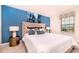 Stylish bedroom with a luxurious upholstered headboard and a serene blue accent wall at 2486 Dubai St, Kissimmee, FL 34747
