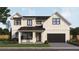 Charming two-story home with black trim, a black metal roof, and an attached garage at 2502 Bethaway Ave, Orlando, FL 32806