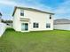Spacious backyard featuring a lush green lawn, a sliding glass door, and a privacy fence at 2837 Palatino Lane, Tavares, FL 32778
