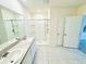 Bright bathroom features a double sink vanity, walk-in shower, and neutral tile flooring at 2837 Palatino Lane, Tavares, FL 32778