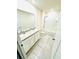 Bathroom with double sink vanity, tile flooring, and a shower-tub combo with white tile surround at 2837 Palatino Lane, Tavares, FL 32778