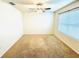 A simple bedroom with carpeted floors, a large window, and bright natural light at 2837 Palatino Lane, Tavares, FL 32778