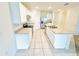 This modern kitchen features white cabinetry, an island sink, and stainless steel appliances at 2837 Palatino Lane, Tavares, FL 32778