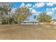 Quaint single-story home with fresh paint, a metal roof, and mature trees sits on a wide, green front lawn at 2980 E Central Ave, Bartow, FL 33830