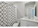 This bathroom features a shower with patterned curtain, white vanity, and a tiled floor at 3069 Cassidy Ln, Haines City, FL 33844