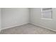 This bedroom has a neutral carpet, base molding and a window with blinds at 3069 Cassidy Ln, Haines City, FL 33844