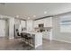 Bright kitchen featuring white cabinets, stainless steel appliances, an island with barstool seating, and tile flooring at 3069 Cassidy Ln, Haines City, FL 33844