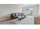 Inviting living room features a leather sofa, area rug, and sliding glass doors with backyard view at 3069 Cassidy Ln, Haines City, FL 33844