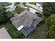 Aerial view of a beautiful home with a large roof, screened-in pool, and well-maintained landscaping at 3111 Indian Trl, Eustis, FL 32726