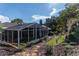 The backyard features a screened lanai and meticulously maintained landscaping with a lush lawn at 3111 Indian Trl, Eustis, FL 32726