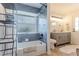Modern bathroom with blue tiled shower, dual sink vanity, and fluffy rug at 3111 Indian Trl, Eustis, FL 32726