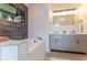 Bathroom with modern double sink vanity, bathtub, and black tiled shower offers a spa-like feel at 3111 Indian Trl, Eustis, FL 32726
