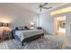 Light-filled bedroom with ceiling fan, soft rug, neutral tones, and an adjacent bathroom at 3111 Indian Trl, Eustis, FL 32726