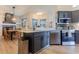 Bright eat-in kitchen featuring stainless appliances, gray cabinets, and an island with breakfast bar at 3111 Indian Trl, Eustis, FL 32726