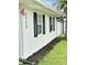 Side view of home showcasing crisp white exterior, black shutters, and well-maintained landscaping at 3117 Shady Pine Ave, Winter Park, FL 32792